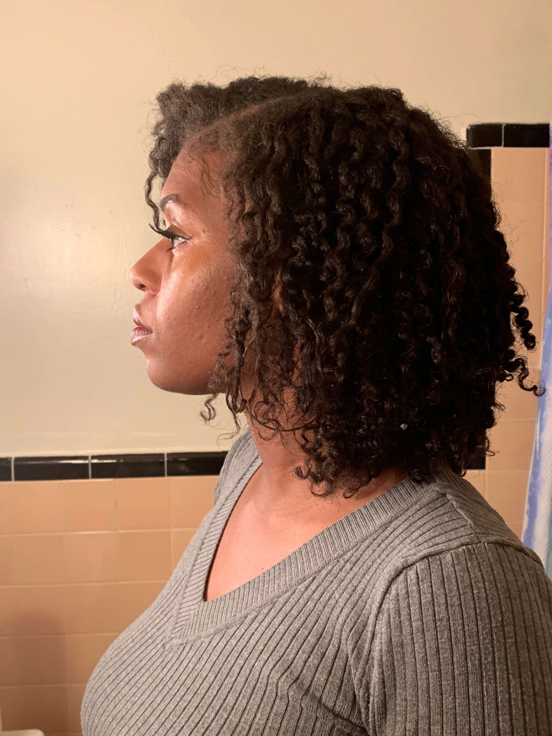 black woman looking into mirror